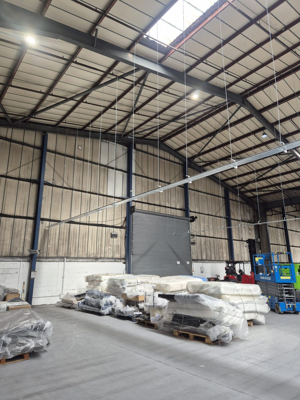 Industrial unit with suspended linear fittings under an exposed steel roof